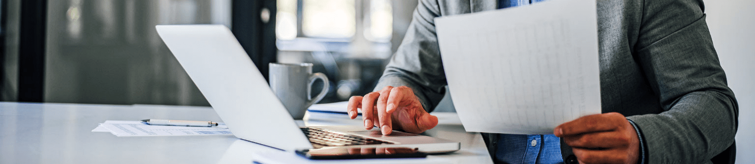 close-up of man working on laptop in office