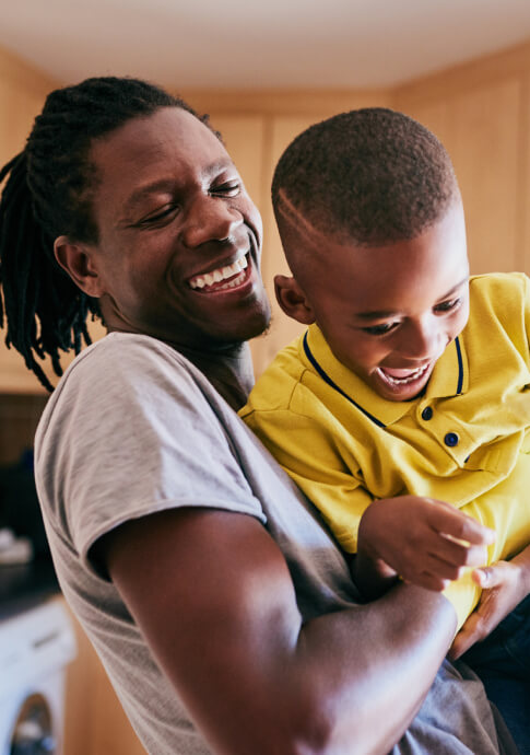 Dad and young kid playing in a kitchen