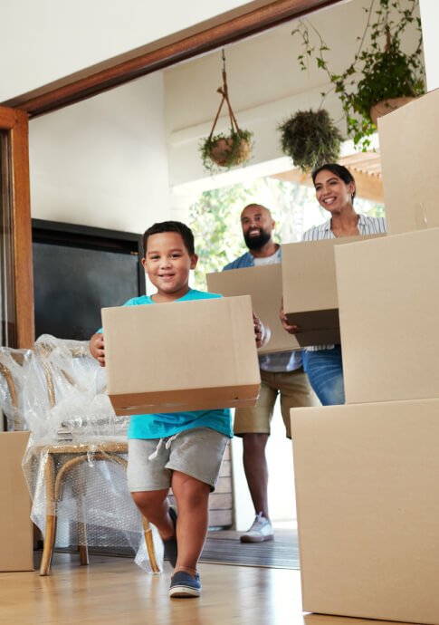 Young family carrying in boxes into a new home