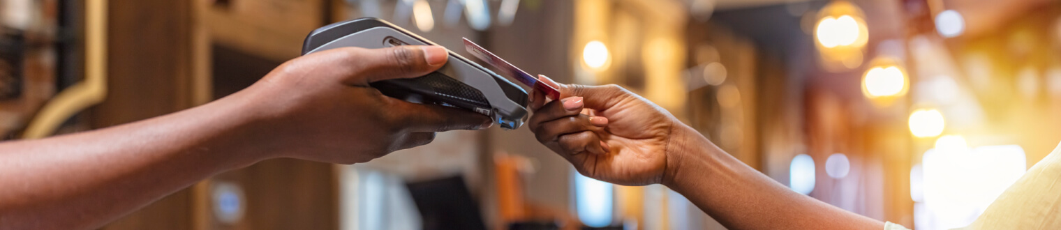 close up of hands holding a credit card using a card reader