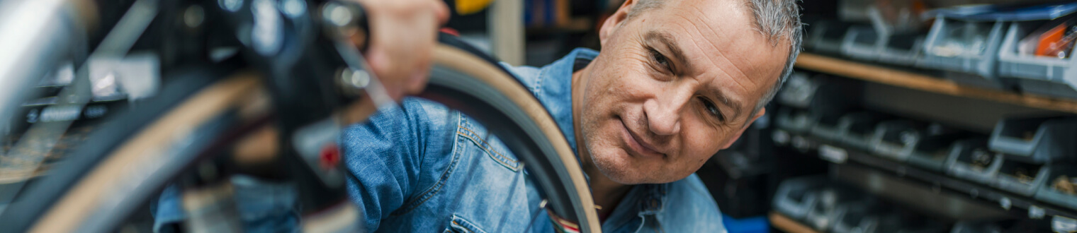 Man inspecting the tire of a bicycle