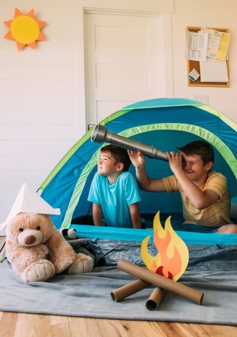 Two kids playing inside a tent